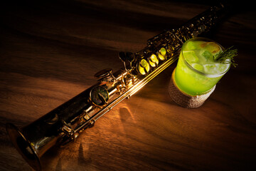 colorful cocktail with brass clarinet or saxophone on wooden table