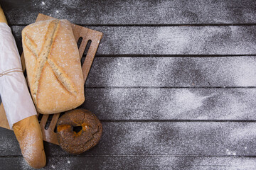Bakery - gold rustic crusty loaves of bread and buns on black chalkboard background top view
