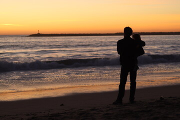Fototapeta na wymiar silhouette of man and child at beach during sunset
