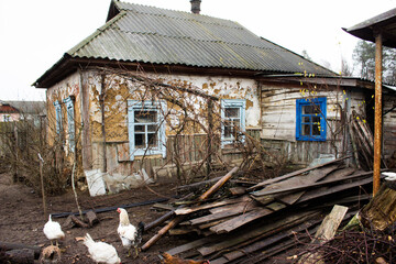 Fototapeta na wymiar A very old house. Abandoned house, old courtyard. Vintage. Windows of an old house. Old yard with chickens. Background.