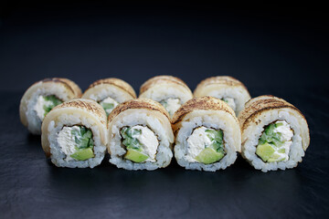 Grilled eel sushi rolls on plate, food background