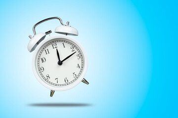 white retro alarm clock floating above floor blue background.