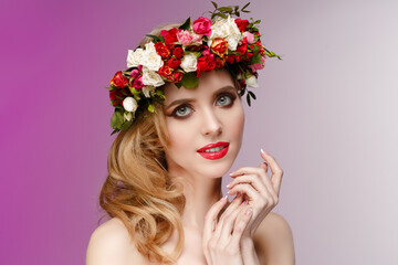 Girl in a wreath of spring flowers. Spring beauty. Woman with flowering plants in her hair.