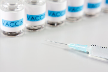 Flacons de vaccin et seringue sur table gris clair