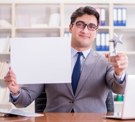 Businessman in office holding a blank message board