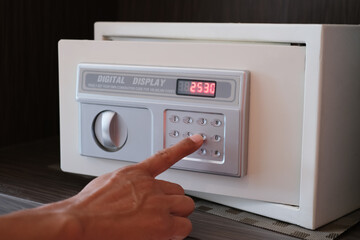 Close up hand opening small digital safe for home or office. Selected focus.