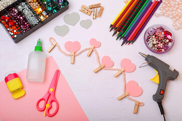 Step 5.
On a light background, colored pencils, wooden clothespins, pebbles, scissors, paper, glue, grater, oil gun, patterns of hearts. Decor hearts.Step by step instructions.Do it yourself