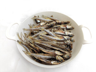 Dried Anchovy Fish decorated with herbs and lemons on a White Background,Selective Focus.