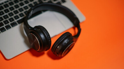 Obraz na płótnie Canvas Black headphones on colored background, laptop, music concept