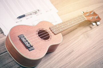 High Angle View Of Guitar With Pen And Musical Note At Table