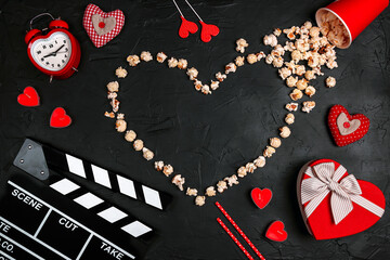 Movie clapper board, popcorn heart, gift box, candles and other love objects on black background...