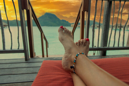 View of the Bora Bora lagoon from perspective of woman relaxing on a lounge chair