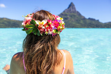 Woman wearing colorful flower crown on vacation at beautiful tropical island Bora Bora in French...