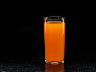 The glass of orange juice on the table