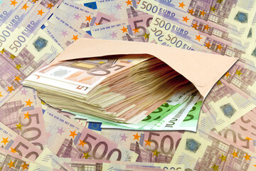 Liasse de billets dans enveloppe sur fond d’euros