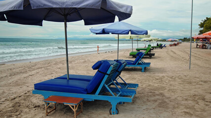 Rows of folded beach umbrellas and empty sunbeds on the beach
