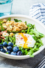 Quinoa salad with berries, poached egg and nuts. Healthy food concept.