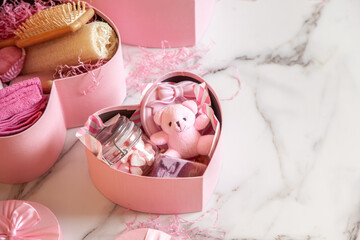 Top view of pink colored heart shaped gift boxes with homemade bath supplies, marshmallow sweets