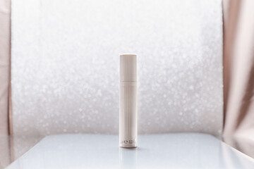 White cosmetic tube on silver glitter background. Beauty ad concept, blog, geometrical minimalism...