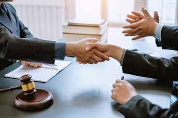 Man lawyer shaking hands with his clients in the office.