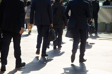 Obraz premium 逆光で朝のビジネスマンの通勤風景