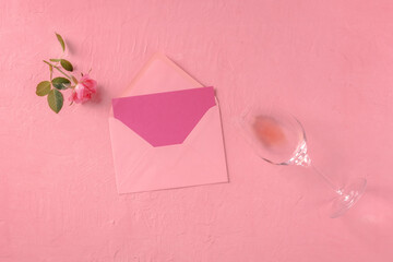 Greeting card, Valentine or invitation mockup, a flatlay with a pink rose and wine, overhead flat lay shot on a pink background, toned image