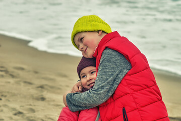 Happy children on a walk by the sea on a winter day. Lifestyle. Happy childhood.