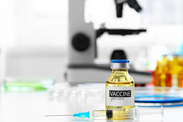Vaccine in vial for injection on table against background of laboratory