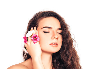 Young woman on a white background with flower in her hand near her face