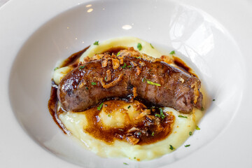 Botifarra - catalonian traditional dish served with potato puree and sauce. Barbecued spanish pork...