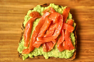 Homemade sandwich with red fish and avocado on grain bread. Delicious and healthy food. High quality photo