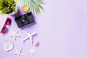Fototapeta na wymiar Top view flat lay mockup of retro camera films, airplane, sunglasses, starfish traveler accessories isolated on a purple background with copy space, Business trip, and vacation summer travel concept