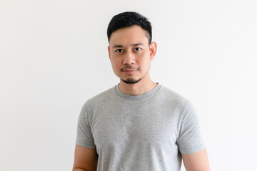 Happy and confident Asian man in grey t-shirt on isolated white background.