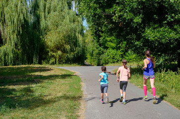 Active family fitness outdoors, running in park, mother and kids exercising and jogging together, family sport with children
