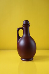 brown bottle ceramic flask on yellow trend color background