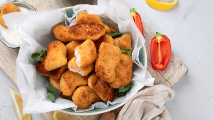 Fried crispy chicken nuggets with ketchup on wooden board
