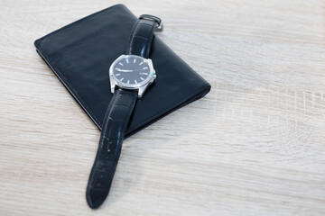 Men's watch and wallet on the table