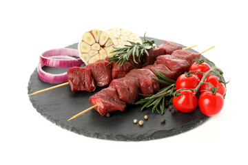 Board with raw shish kebab meat and vegetables isolated on white background