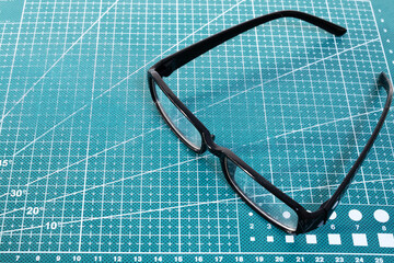 Black rimmed glasses on the cutting mat