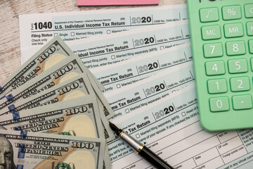 1040 Tax form, calculator and  pen us dollars