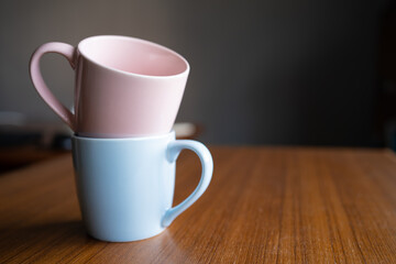 Pink mug on a blue mug. Gender color stereotypes concept. Pink is associated with girls and blue is associated with boys.