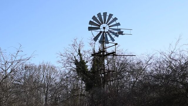 Winter landscape with old wind pump in the forest