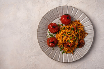 Pasta with baked cherry tomatoes, cheese and parsley on light background, top view, copy space