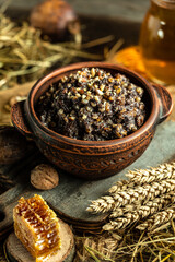 Kutia. Traditional Christmas ceremonial grain dish with honey, raisins and poppy seeds on wooden table. vertical image
