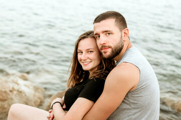 Obraz premium Happy young couple in love, hugging and kissing on the beach