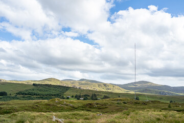 Fototapeta na wymiar Street view of transmitter tower on an agricultural field in the irish highlands by Glenties in County Donegal.