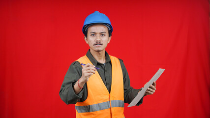 asian construction worker man wearing unifrom and helmet writting in paper isolated red background