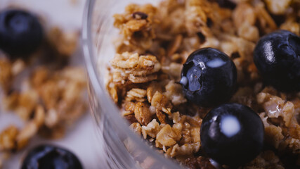 Healthy eating. Natural breakfast with cereals granola, blueberries White background, organic vegetarian food. Morning diet light meal.  Close up