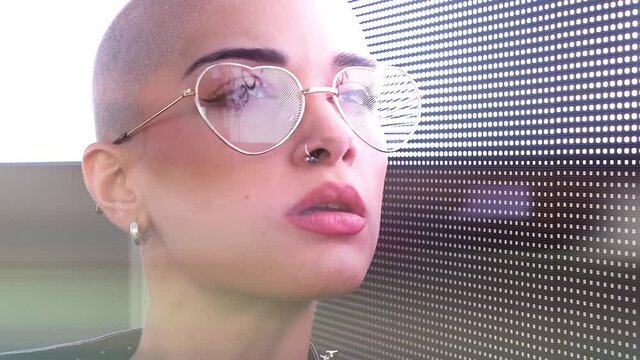 Cinematic image of a beautiful young woman posing against a led panel. Concept about lifestyle and the 2021 cyberpunk fashion look