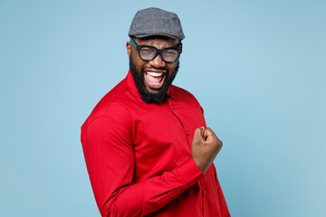 Side view of joyful young bearded african american man 20s wearing casual red shirt cap eyeglasses...